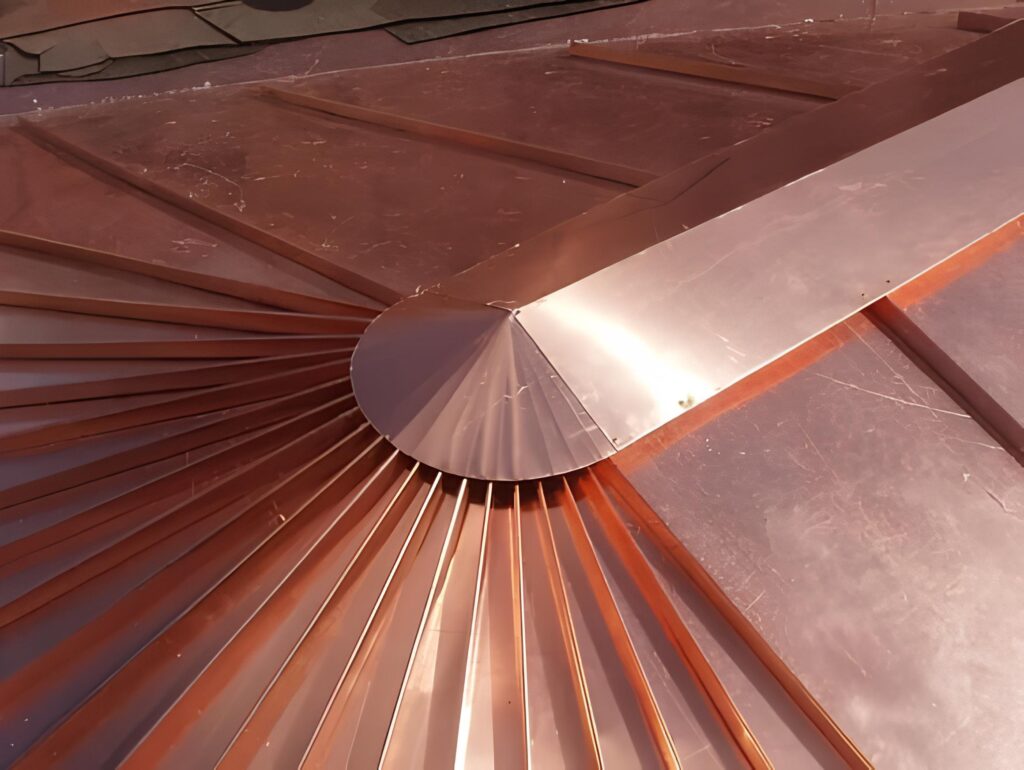 Détail d'un élément de toiture en cuivre, présentant un design radial brillant avec des bandes rayonnantes et une section plane.
