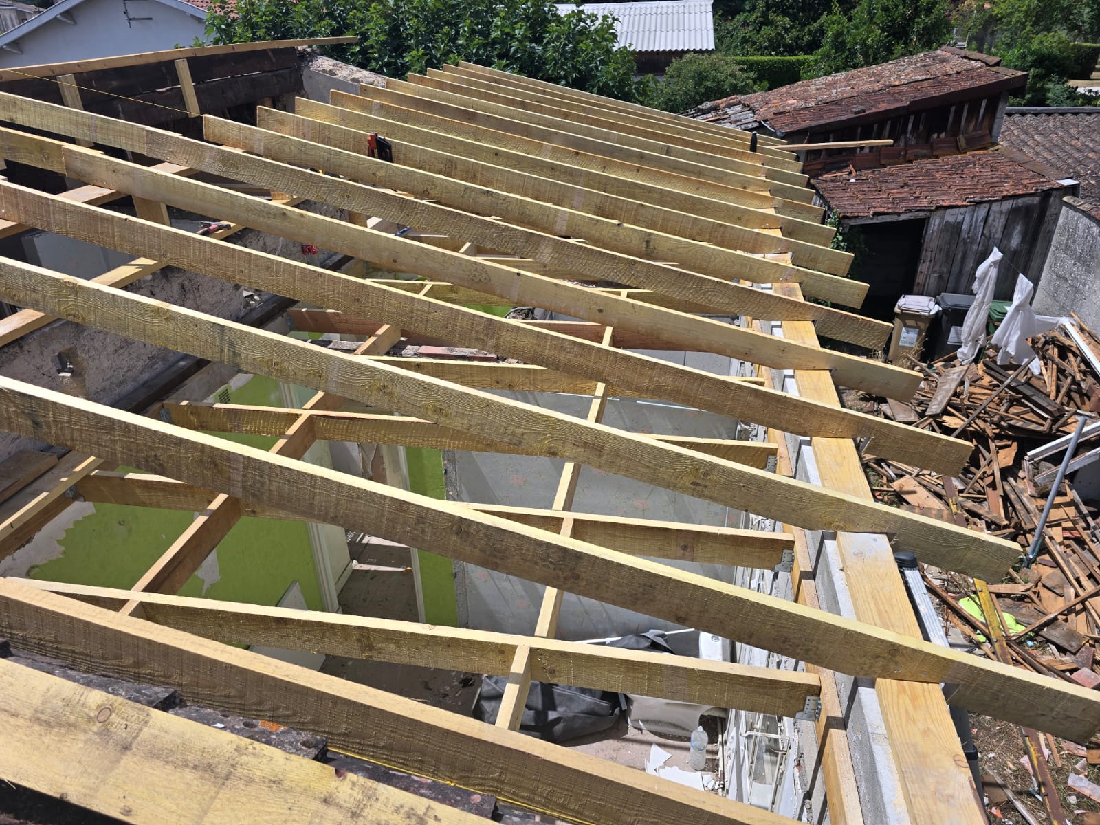 Charpente bois et chevrons pour rénovation de toiture Installation de chevrons sur une charpente en bois neuve lors de la rénovation d'une toiture de maison.