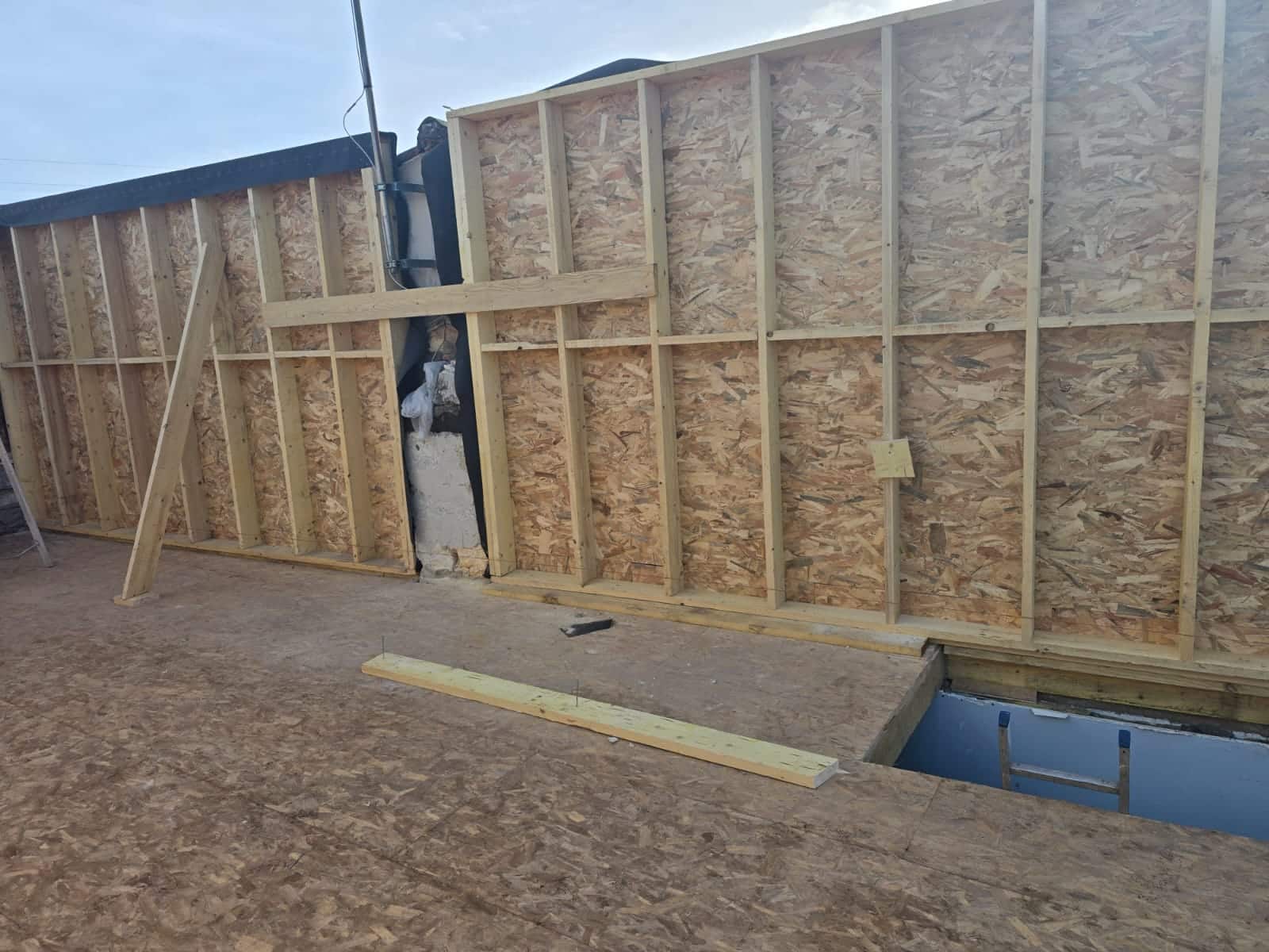 Mur à ossature bois avec panneaux OSB sur un chantier de construction résidentielle.