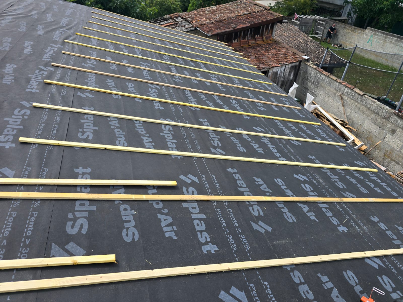 Écran de sous-toiture Siplast Sup'Air posé avec liteaux en bois sur une charpente de maison en rénovation.