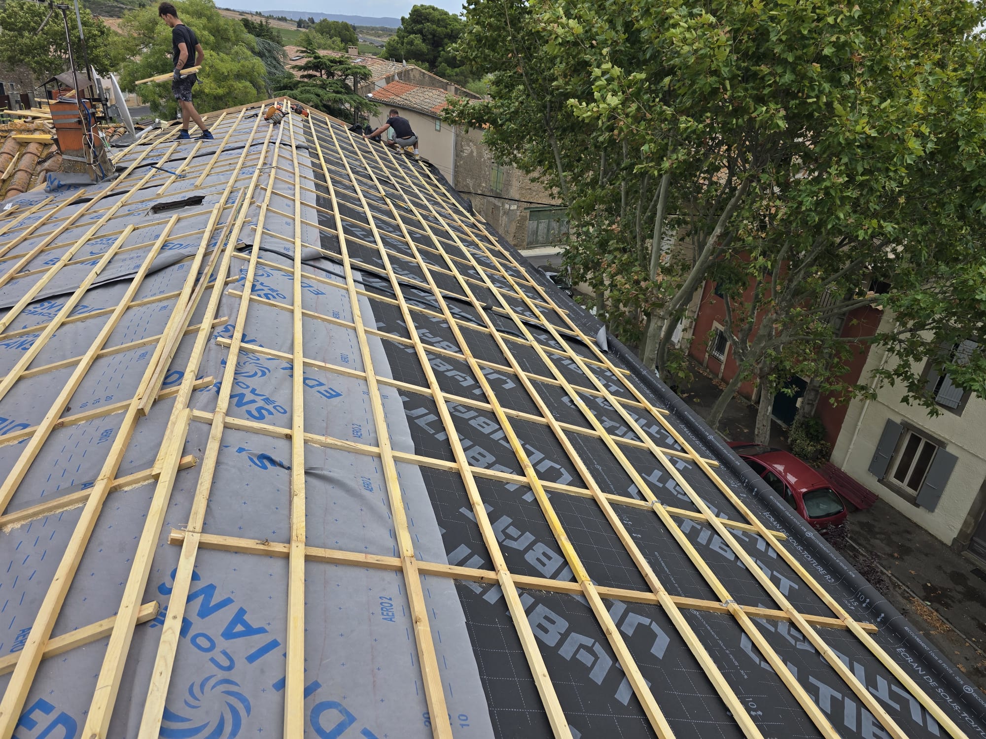 Couvreurs posant des liteaux sur un écran de sous-toiture Aero 2 lors de la rénovation d'un toit incliné.