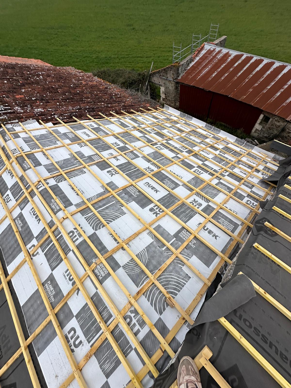 Toiture en rénovation avec pose d'un écran de sous-toiture NUUK et de liteaux en bois sur charpente.